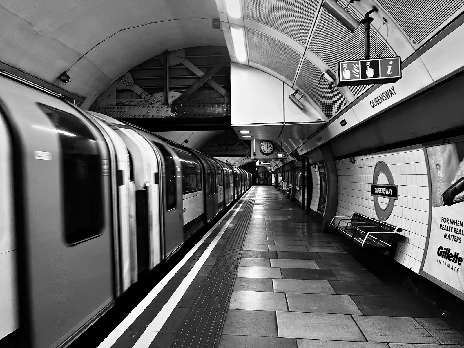 A Central line train at the platform at Queensway station
