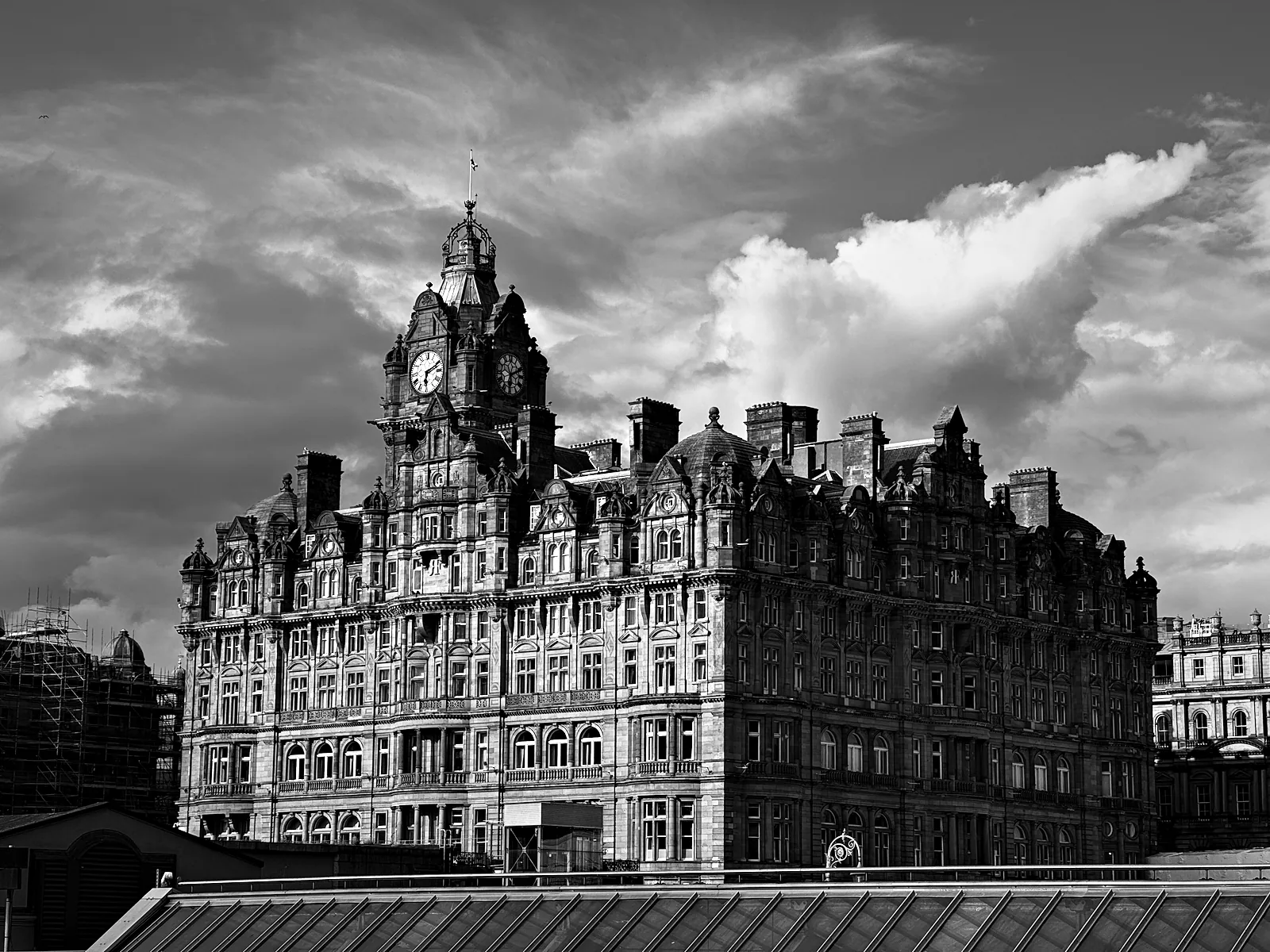 The Balmoral Hotel and its clock tower under big clouds at the east end of Princes Street