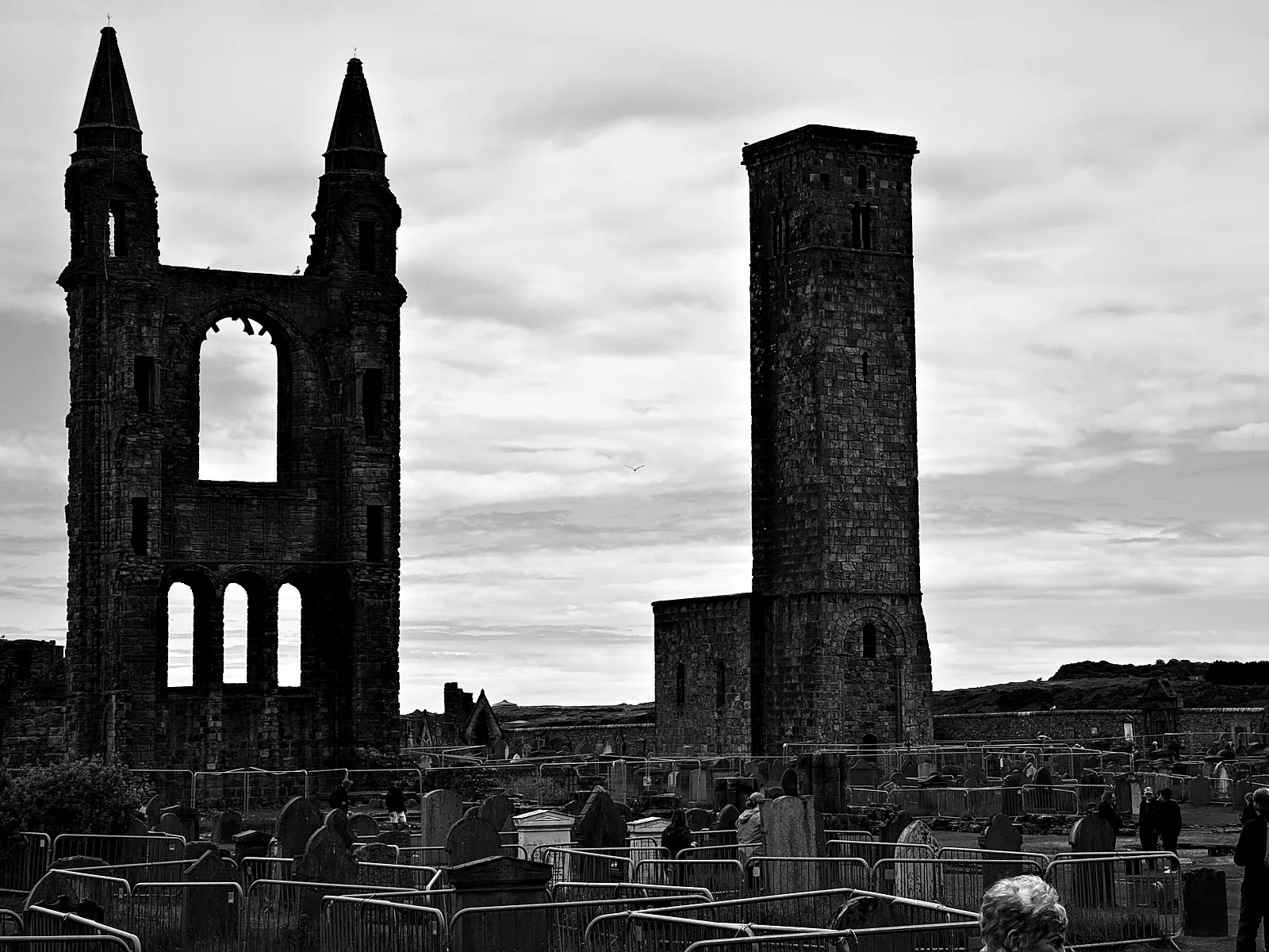 The ruined east gable of St Andrews Cathedral and St Rule's Tower above gravestones and temporary fencing