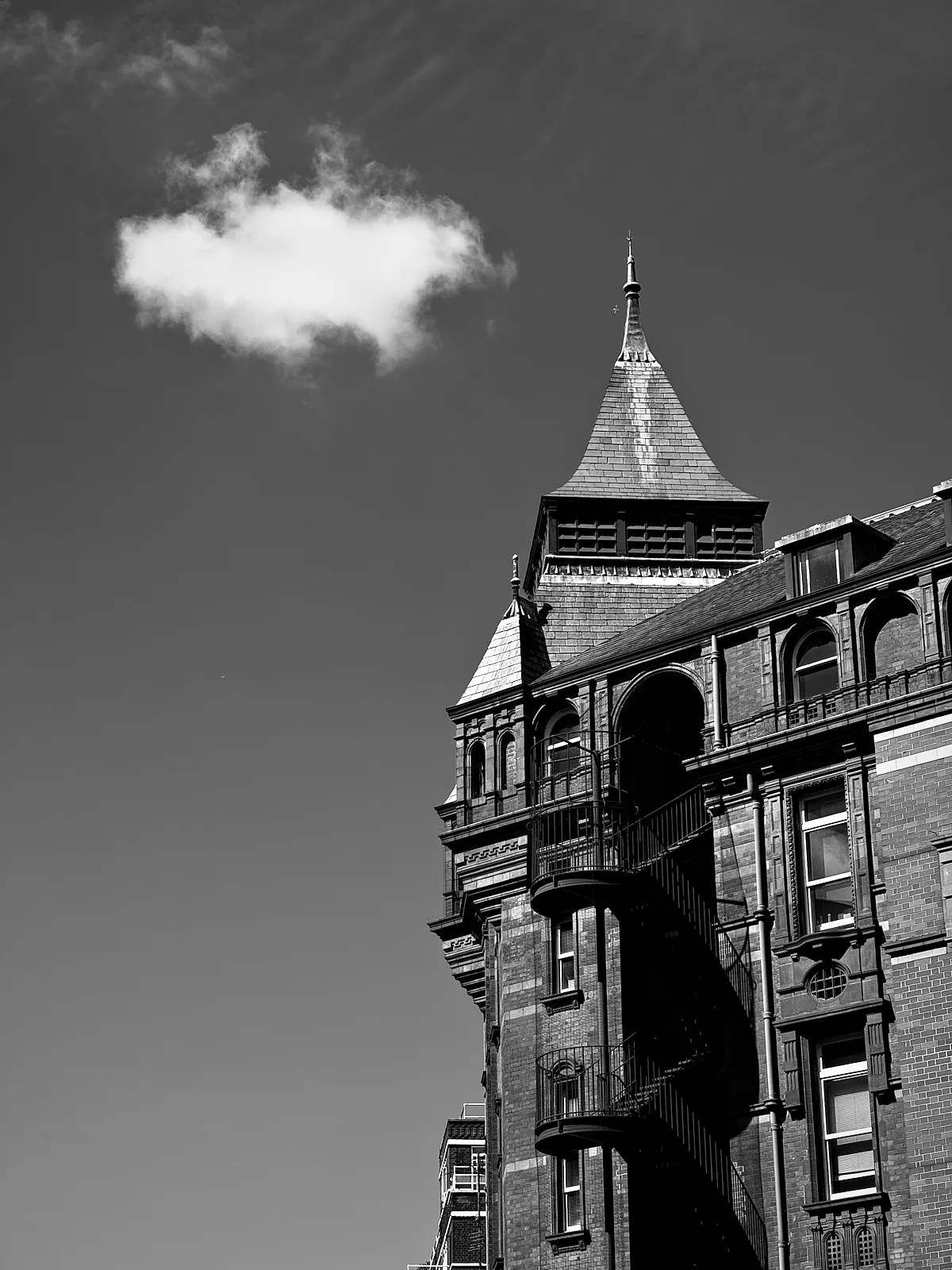 The red-brick Cruciform Building's turret and gables against a clear sky on Gower Street