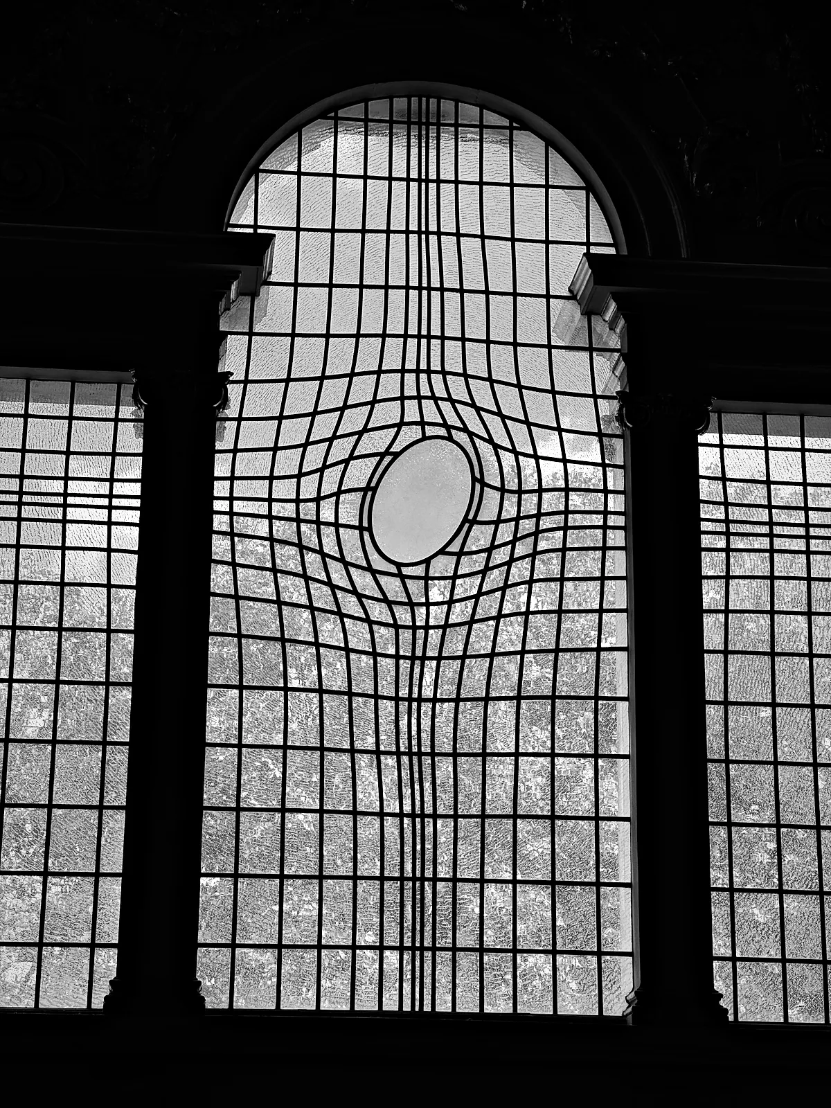 The east window of St Martin-in-the-Fields, its grid of glazing bars warped around an oval