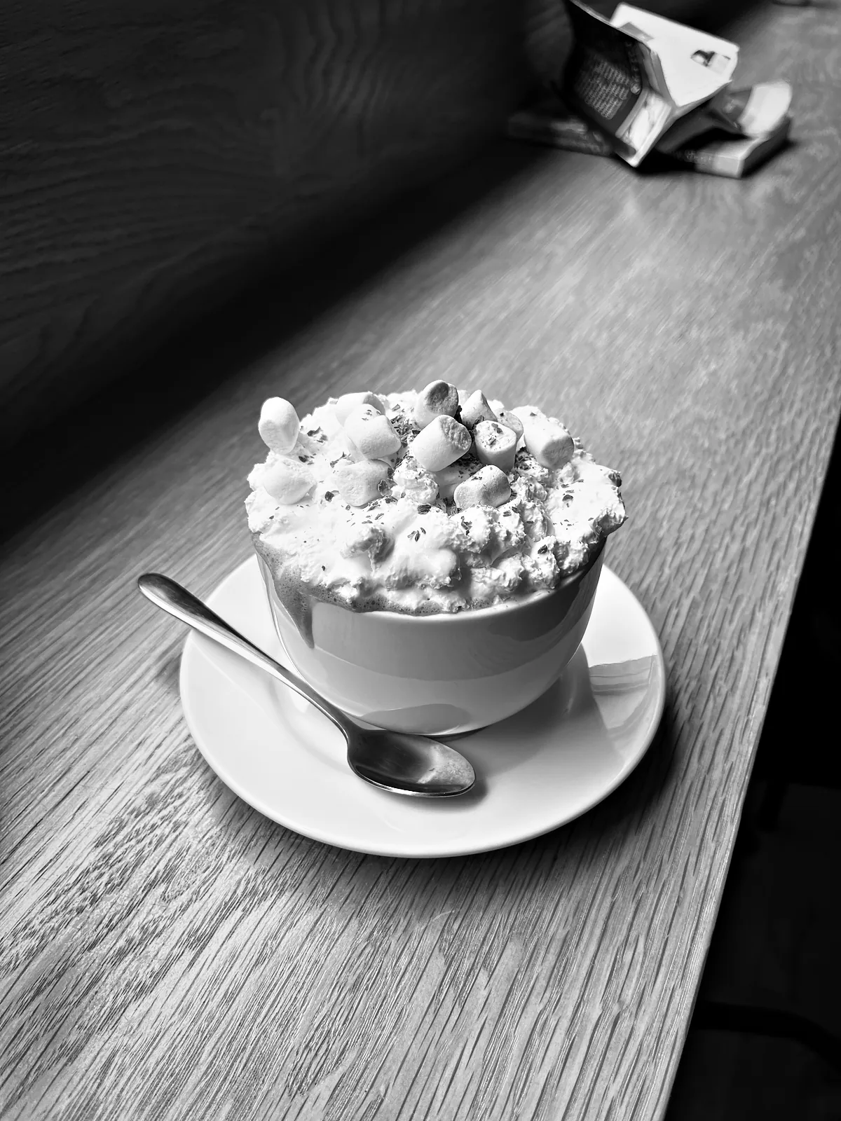 A cup of hot chocolate heaped with marshmallows on a saucer at The Bath Chocolate Company